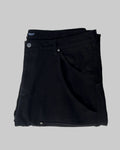 Folded black pants with a brand label on a white background