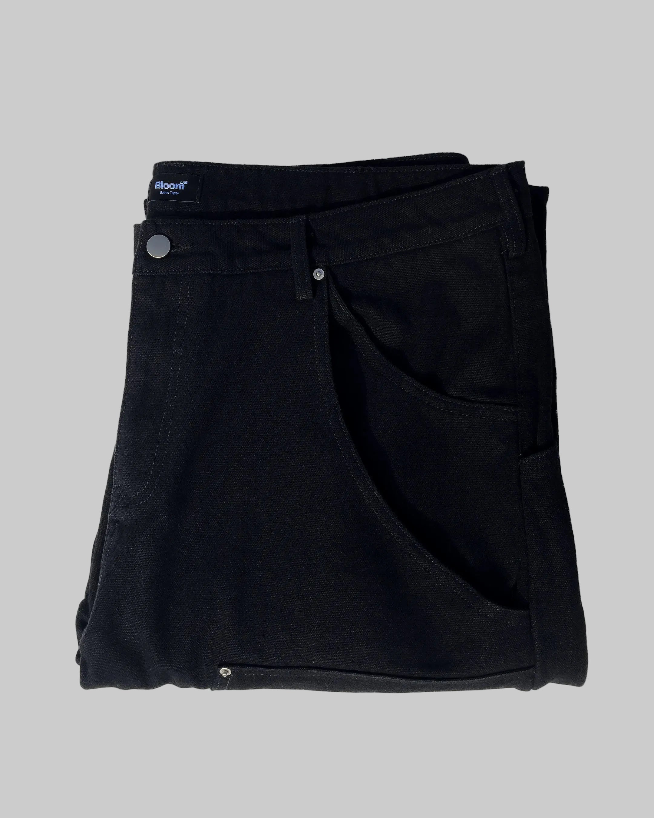 Folded black pants with a brand label on a white background